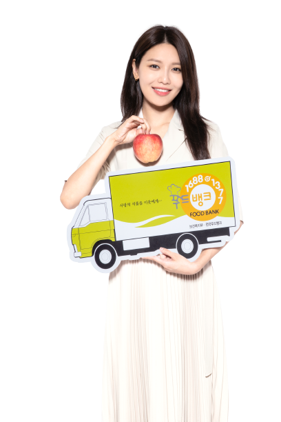 사과 모형과 푸드뱅크 트럭 모형을 들고 있는 홍보대사 가수 수영
